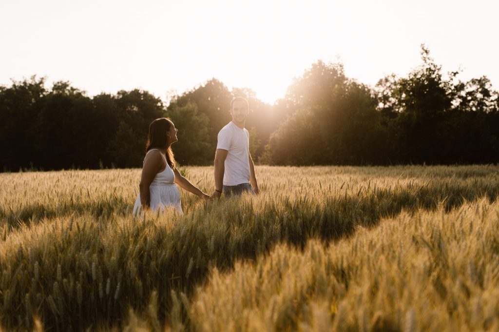 Portrait couple au soleil couchant dans un champ de blé