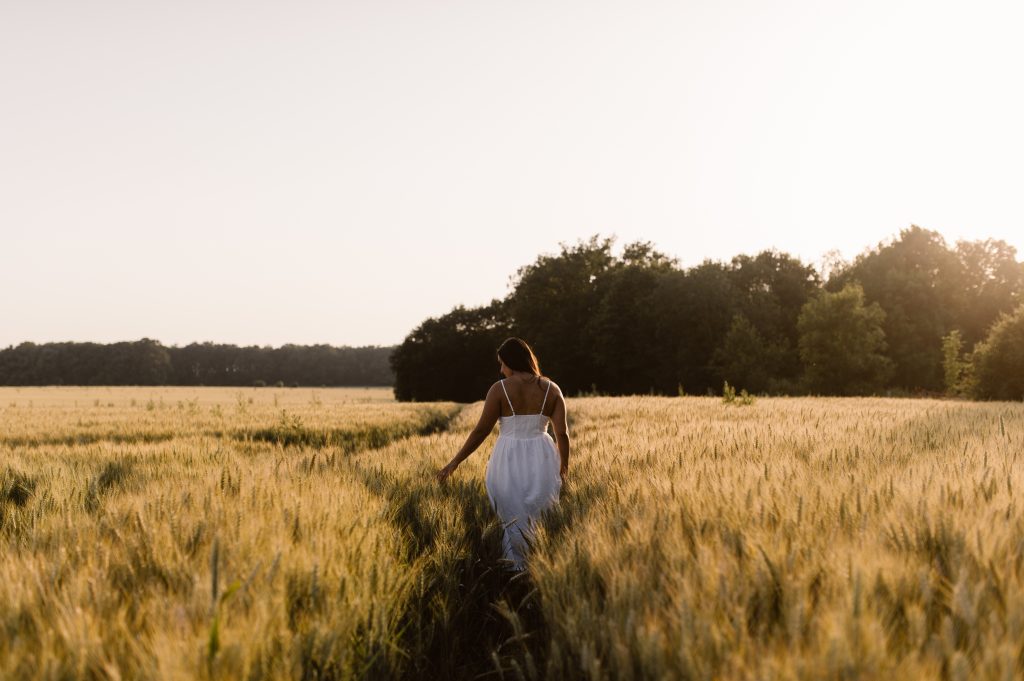 Femme au soleil couchant dans un champ de blé