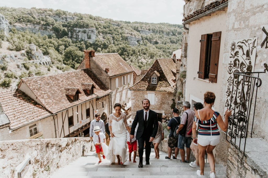 Les mariés montent les escaliers pour accéder à l'église