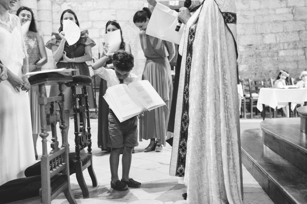Garçon d'honneur tenant le livret de messe pendant le mariage