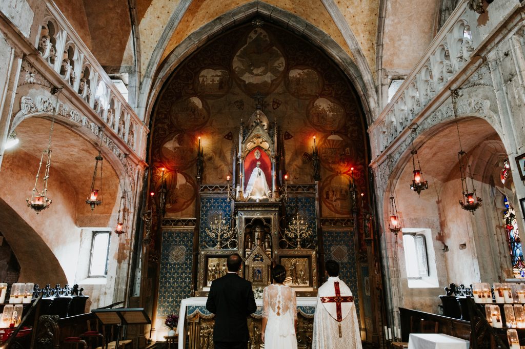Cérémonie du mariage à l'église avec les mariés et le prêtre de dos