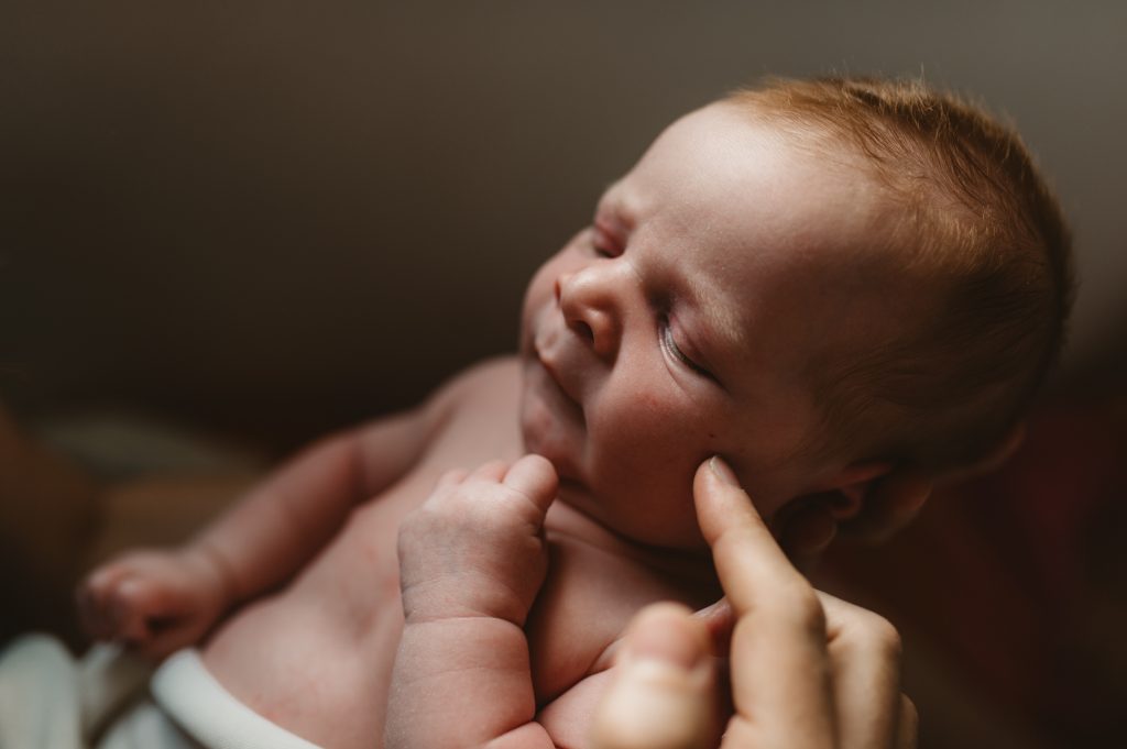 Nouveau né blotti dans les bras de ses parents