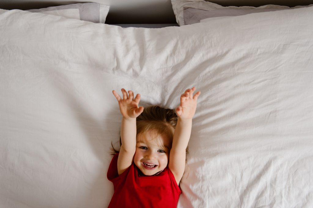 Petite fille sur le lit des parents