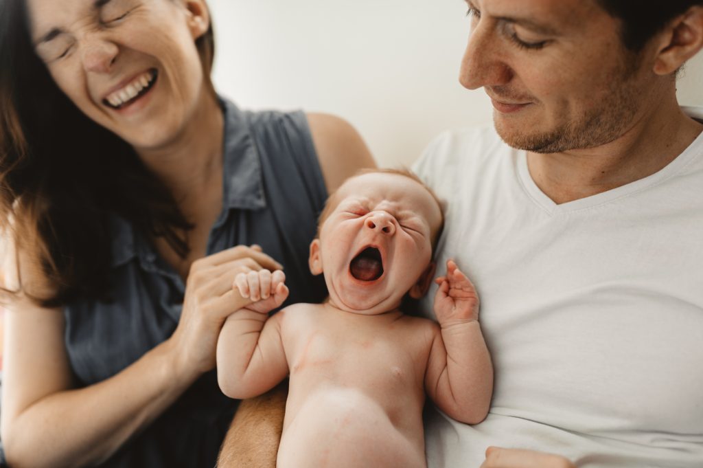 Portrait naissance Paris Bébé baille dans les bras de ses parents