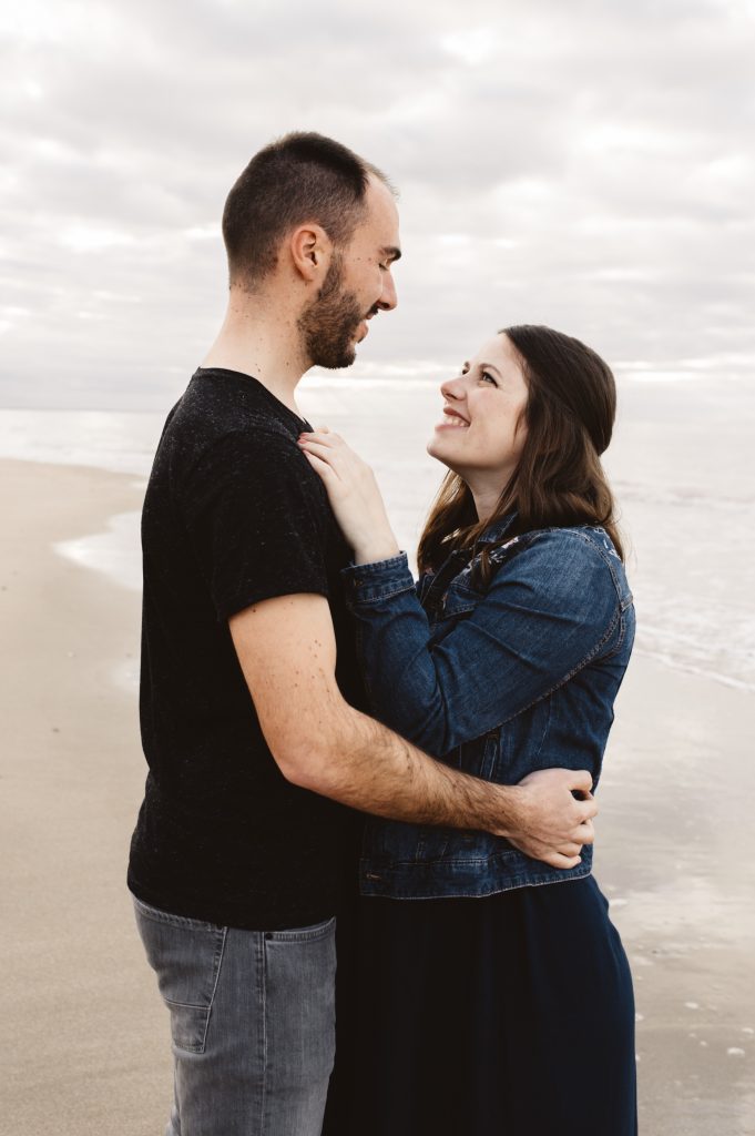 Echange de regard d'un couple sur la plage pour une séance grossesse en normandie