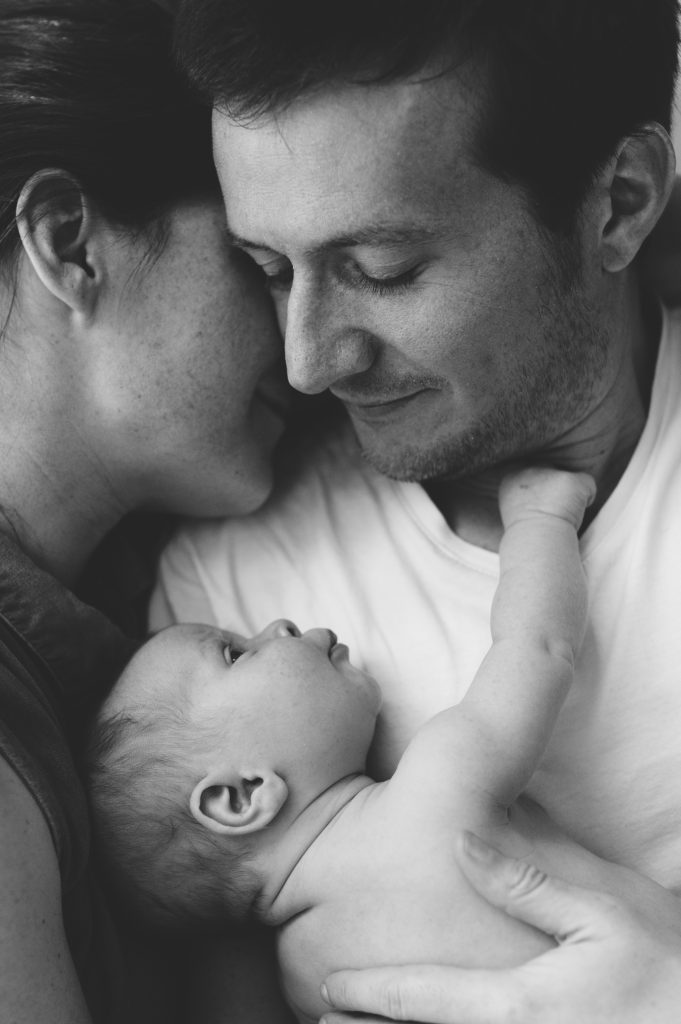 Moment complice entre les parents et leur bébé