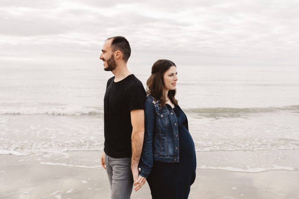 Couple dos à dos sur la plage en Normandie