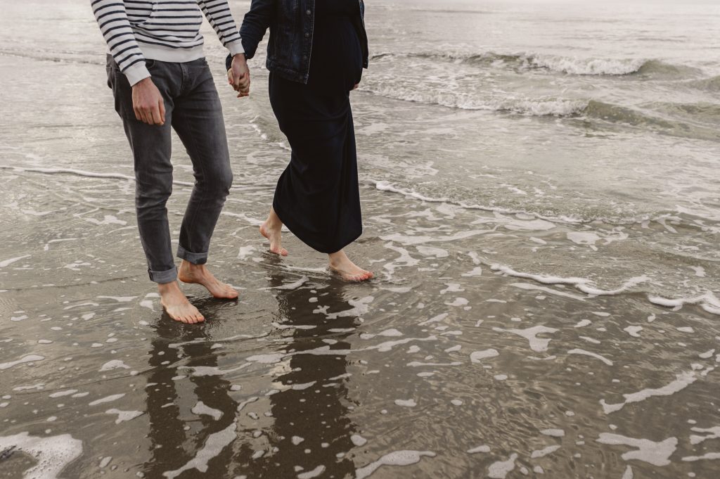 Couple marchant les pieds dans l'eau sur la plage