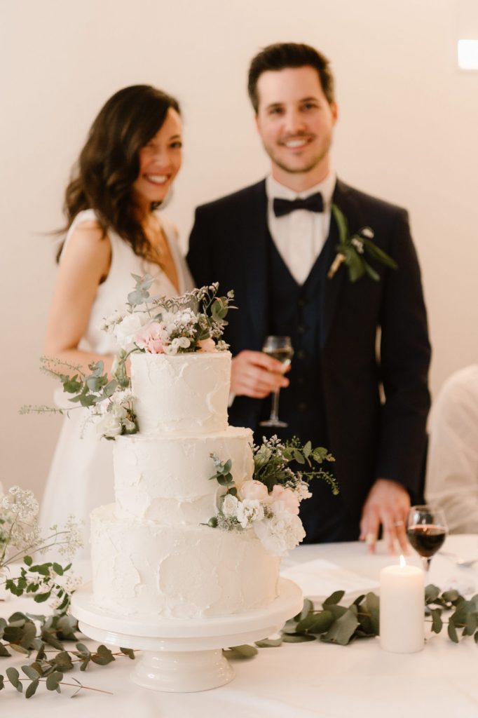 Les mariés derrière leur gâteau de mariage